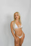 Woman wearing a white bikini against a plain background