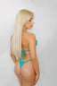 Woman wearing a turquoise bikini against a white background