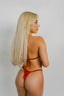 Woman wearing a red bikini against a plain background