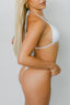 Woman wearing a white bikini against a plain background